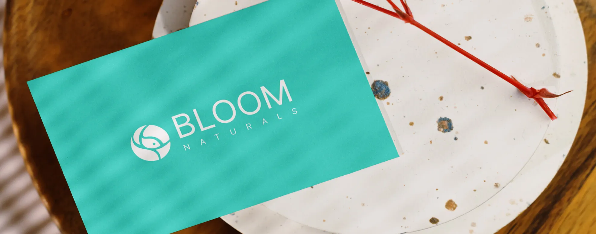 The Bloom Naturals logo — a soft, flowing rose monogram